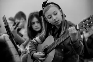 maedchen mit gitarre in der hand auf dem gitarrenklassenkonzert auf schloss boitzenburg