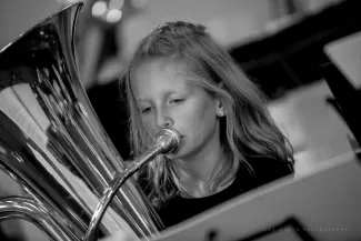junge Schuelerin uebt mit Tuba f&uuml;r das Blaeserklassenkonzert 