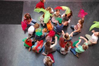 Kinder tanzen und werden bunte tuecher in die luft im emp-kurs an der schule schulzendorf