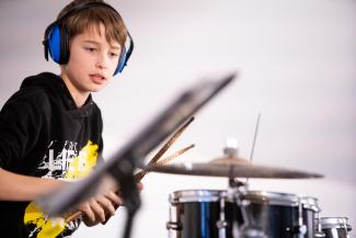 Kind spielt Schlagzeug - Bläserklassenkonzert 2022