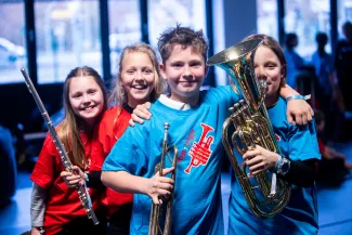 Kinder vor dem Konzert posieren mit ihren instrumenten