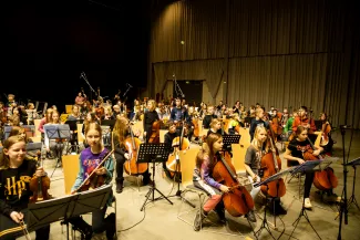 Gro&szlig;e Gruppe der Streicherklassen, zu sehen sind vor allem die Violoncellistinnen und -cellisten