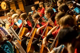 Gruppe von Violoncellistinnen und -cellisten beim Streicherklassenkonzert