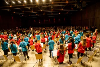 Blick von hinten auf die jungen Streicherinnen und Streicher beim Streicherklassenkonzert, die ihren Applaus genie&szlig;en