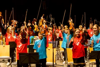 Die jungen Streicherinnen und Streicher heben ihre B&ouml;gen hoch