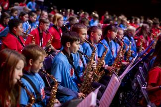 Kinder auf der Bühne beim Bläserklassenkonzert 2023, an den Saxophonen